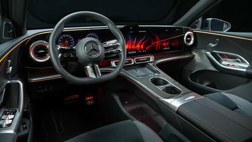 "Luxury Mercedes-Benz interior with a continuous hyperscreen, ambient interior lighting, multi-spoke steering wheel and premium leather trim"