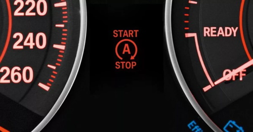 "Car instrument panel showing the engine automatic start-stop indicator light marked with a circled letter A between the speedometer and tachometer"