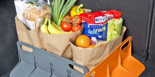 "Car trunk with grocery paper bags filled with fruits, vegetables and food, fixed by two plastic anti-slip cargo stoppers to prevent sliding during driving"