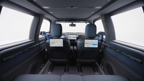 "Spacious modern car rear interior with entertainment screens mounted on the front seat headrests"